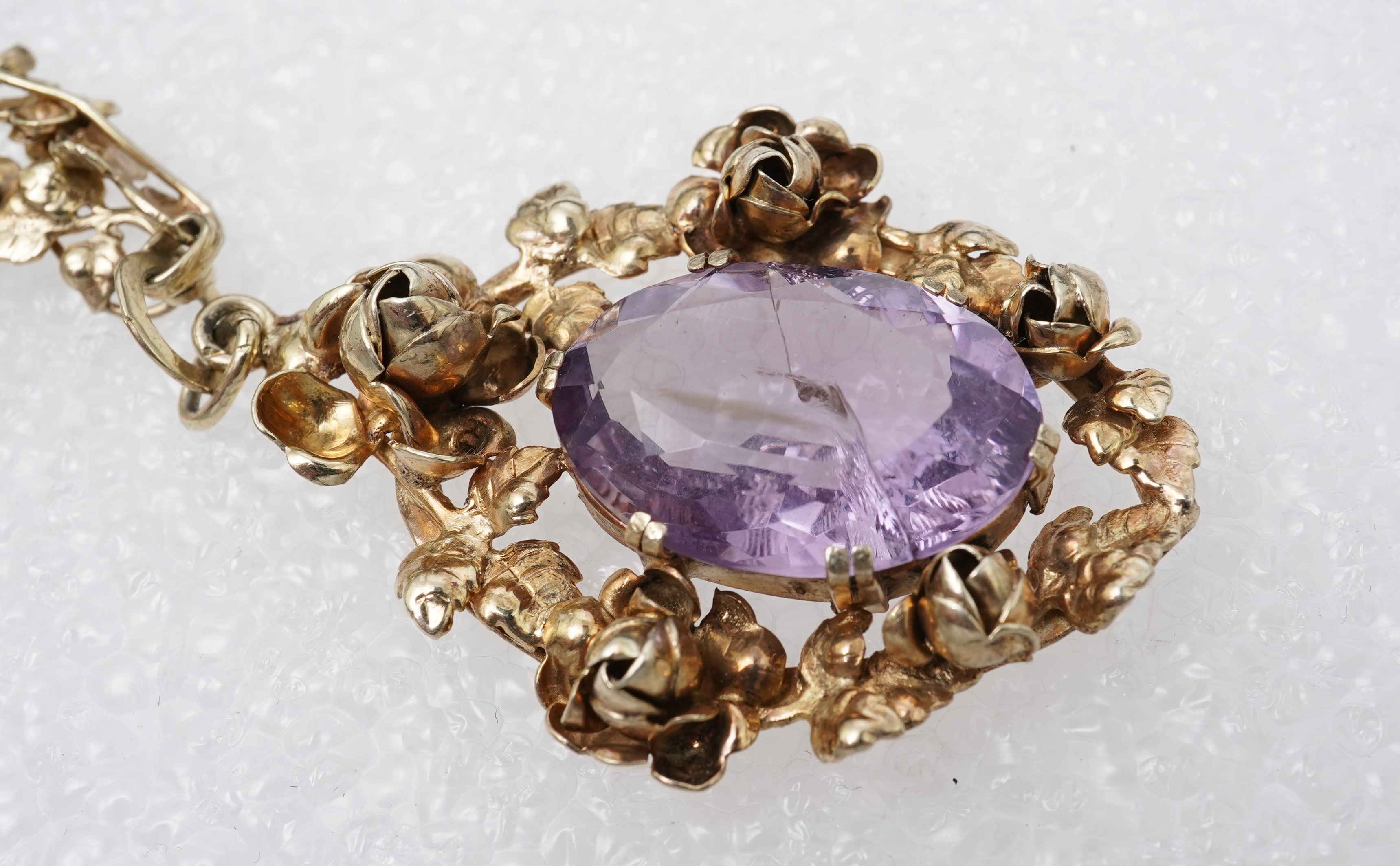 An amethyst ring, necklace and pendant, comprising: an oval amethyst set in a floral gilt silver necklace, length 32cm; an oval amethyst and seed pearl pendant, length 3.7cm; and a ring set with an oval amethyst, mounted